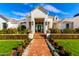 Eye-catching home entrance with brick walkway, lush garden beds, and pristine lawn, offering a welcoming ambiance at 20690 E Sunset Dr, Queen Creek, AZ 85142