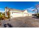 Exterior shot showing garage doors and driveway, complemented by well-maintained landscaping at 20690 E Sunset Dr, Queen Creek, AZ 85142