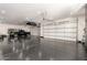 Spacious garage with a sleek, epoxy floor offering ample space for vehicles, bikes, and storage at 20690 E Sunset Dr, Queen Creek, AZ 85142