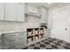 Laundry room with custom cabinets, open storage, and decorative patterned tile flooring at 20690 E Sunset Dr, Queen Creek, AZ 85142