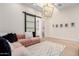 Cozy living room featuring a pink sectional, area rug, modern light fixture, and vaulted ceilings at 20690 E Sunset Dr, Queen Creek, AZ 85142