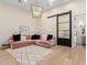 Stylish living room featuring a comfortable pink sectional, modern lighting, and open concept kitchen at 20690 E Sunset Dr, Queen Creek, AZ 85142