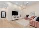 Elegant living room with high ceilings, modern lighting fixture, and stylish pink sofa at 20690 E Sunset Dr, Queen Creek, AZ 85142