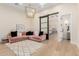 Stylish living room with a comfortable pink sectional, modern lighting, and sliding barn door feature at 20690 E Sunset Dr, Queen Creek, AZ 85142