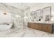 A sleek bathroom featuring marble floors and walls, dual sinks, soaking tub and a glass enclosed shower at 20690 E Sunset Dr, Queen Creek, AZ 85142