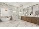 A modern bathroom featuring marble floors and walls, dual sinks, soaking tub and a glass enclosed shower at 20690 E Sunset Dr, Queen Creek, AZ 85142