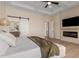 Bright main bedroom featuring a modern fireplace, tv, barn door and ensuite bath at 20690 E Sunset Dr, Queen Creek, AZ 85142