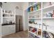 Well-organized pantry with open shelves, drawers, and a stainless steel refrigerator for extra storage at 20690 E Sunset Dr, Queen Creek, AZ 85142