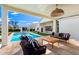 Inviting covered patio seating area overlooks the pool and backyard, offering a luxurious outdoor living space at 20690 E Sunset Dr, Queen Creek, AZ 85142