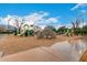 Community playground with slides, climbing structures, and a sandy play area under a partly cloudy sky at 20690 E Sunset Dr, Queen Creek, AZ 85142
