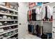 Walk-in closet featuring extensive shoe shelving, organized clothes racks, and efficient storage solutions at 20690 E Sunset Dr, Queen Creek, AZ 85142