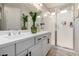 Bathroom featuring double sinks, white cabinetry, modern fixtures, and tiled glass shower at 2571 S Melvin St, Gilbert, AZ 85295
