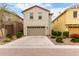 Two-story home exterior with attached garage, neutral stucco, and desert landscaping at 2571 S Melvin St, Gilbert, AZ 85295