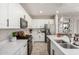 Bright kitchen features white cabinets, stainless appliances, quartz countertops and wood-look tile at 2571 S Melvin St, Gilbert, AZ 85295