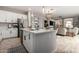 Open kitchen with island, stainless appliances, pendant lights and view to the living room at 2571 S Melvin St, Gilbert, AZ 85295