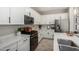 Bright kitchen features white cabinets, stainless appliances, quartz countertops and wood-look tile at 2571 S Melvin St, Gilbert, AZ 85295