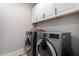 Laundry room with front loading washer and dryer and built-in cabinets at 2571 S Melvin St, Gilbert, AZ 85295