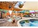 Lush backyard with pool under a pergola, complemented by outdoor seating areas and shade for relaxation at 3126 N 17Th Dr, Phoenix, AZ 85015