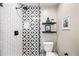 Modern bathroom featuring a beautifully tiled shower with a black rainfall showerhead, and decorative shelving at 3126 N 17Th Dr, Phoenix, AZ 85015