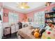 Bright bedroom with pink walls, white shutters, a ceiling fan, and a bed with decorative plush animals at 3126 N 17Th Dr, Phoenix, AZ 85015