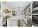 Bright kitchen with stainless appliances, large island, and white cabinetry with designer backsplash and hood vent at 3126 N 17Th Dr, Phoenix, AZ 85015