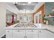 Modern kitchen featuring stainless hood vent, white countertops, and gas cooktop with dining area in the background at 3126 N 17Th Dr, Phoenix, AZ 85015