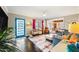 Open living room with a colorful rug, dark hardwood floors, and a brightly colored blue front door at 3126 N 17Th Dr, Phoenix, AZ 85015