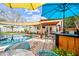 Backyard pool area with patio seating, shade umbrellas, and a charming outdoor bar for entertaining at 3126 N 17Th Dr, Phoenix, AZ 85015