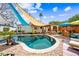 Beautiful pool with stone surround, shade covers, covered seating and backyard entertaining space at 3126 N 17Th Dr, Phoenix, AZ 85015