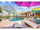 Relaxing backyard features a sparkling pool surrounded by lounge chairs and a covered patio at 3126 N 17Th Dr, Phoenix, AZ 85015