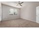 Bright bedroom features plush carpet, a ceiling fan, and a window with blinds at 3302 N 7Th St # 108, Phoenix, AZ 85014