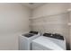 Bright laundry room featuring a washer, dryer, and wire shelving for storage at 3302 N 7Th St # 108, Phoenix, AZ 85014