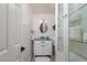 Clean bathroom with a vanity, framed mirror, and storage cabinet with glass shelves at 3514 N 83Rd St, Scottsdale, AZ 85251