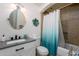 Well-lit bathroom featuring a stylish vanity, decorative mirror, and a shower with unique tile accents at 3514 N 83Rd St, Scottsdale, AZ 85251
