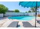Sparkling swimming pool with lounge chairs and large umbrella for shade at 3514 N 83Rd St, Scottsdale, AZ 85251