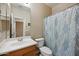 Cozy bathroom featuring a wood vanity, toilet, mirror and a shower with leaf patterned curtain at 4330 W Aracely Dr, New River, AZ 85087