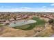Stunning aerial view of a golf course community with a pond and lush green fairways at 4515 E Rakestraw Ln, Gilbert, AZ 85298