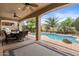 Lush backyard featuring a covered patio, outdoor dining, sparkling pool, and mature landscaping at 4515 E Rakestraw Ln, Gilbert, AZ 85298