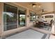 Covered patio featuring ceiling fans, sliding glass door, outdoor dining, and neutral tiling at 4515 E Rakestraw Ln, Gilbert, AZ 85298