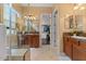 Bright bathroom featuring dual vanities, walk-in shower, walk-in closet, and tile flooring at 4515 E Rakestraw Ln, Gilbert, AZ 85298