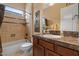 Contemporary bathroom featuring dark wood cabinets, marble countertops, shower, and neutral tiling at 4515 E Rakestraw Ln, Gilbert, AZ 85298