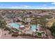 Aerial view of the community pools, tennis courts, clubhouse, and surrounding landscape at 4515 E Rakestraw Ln, Gilbert, AZ 85298