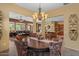 Elegant dining room with round table, chandelier, and views to the living room and kitchen at 4515 E Rakestraw Ln, Gilbert, AZ 85298