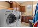 Laundry room with side-by-side washer and dryer, built-in cabinets, and sink at 4515 E Rakestraw Ln, Gilbert, AZ 85298
