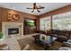 Cozy living room with a fireplace, TV, and a comfortable leather sectional sofa at 4515 E Rakestraw Ln, Gilbert, AZ 85298