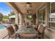 Covered patio with ceiling fans, TV, and ample seating by the refreshing pool area at 4515 E Rakestraw Ln, Gilbert, AZ 85298