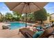 Relaxing poolside with shaded lounge chairs and desert landscaping, perfect for sunny afternoons at 4515 E Rakestraw Ln, Gilbert, AZ 85298