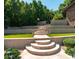 Multi-tiered backyard with stone steps, retaining walls, green grass, and lush landscaping at 5040 N Arcadia Dr, Phoenix, AZ 85018