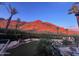 Stunning backyard view with lush greenery, putting green, a pool, and mountain views at sunset at 5040 N Arcadia Dr, Phoenix, AZ 85018