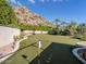 Backyard putting green with lush landscaping, mountain views, and plenty of space to enjoy outdoor activities at 5040 N Arcadia Dr, Phoenix, AZ 85018
